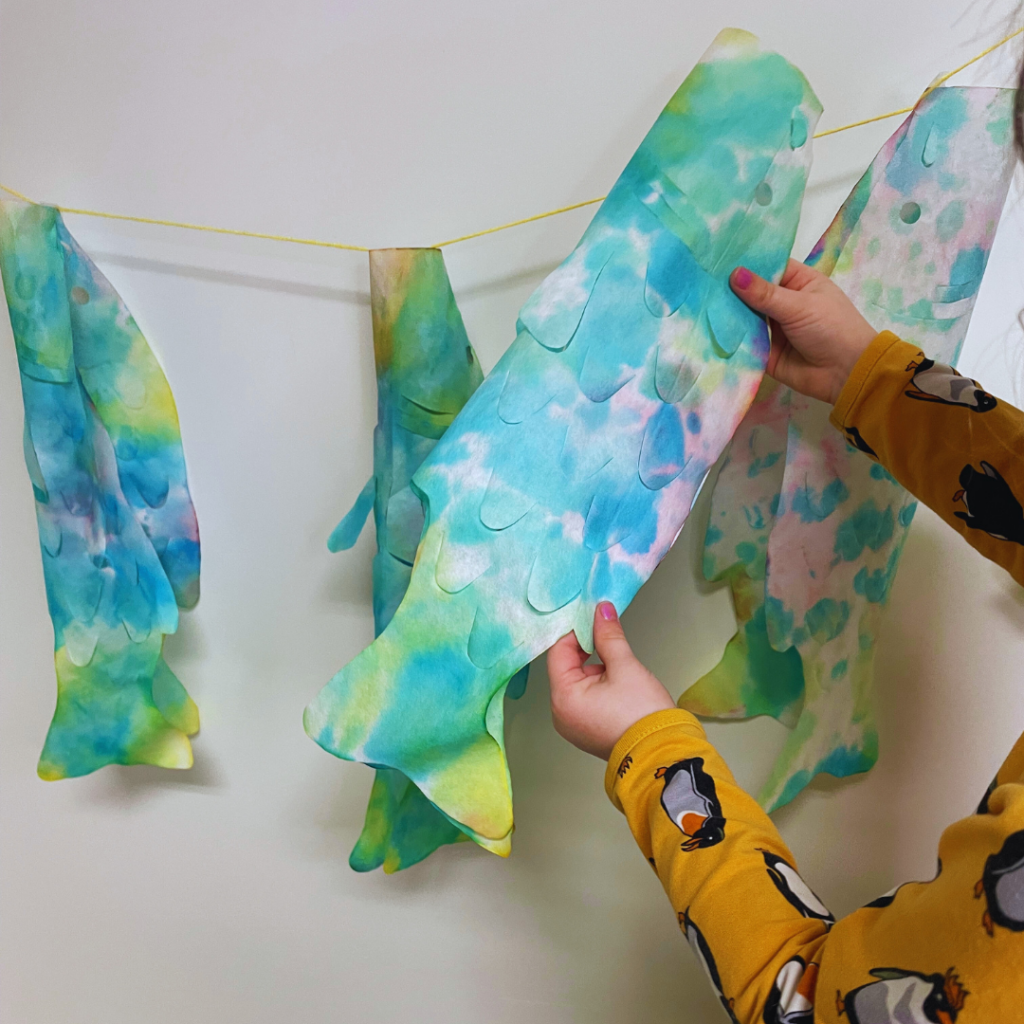 Student creating and coloring Carp windsocks for International Children's Day classroom activity.